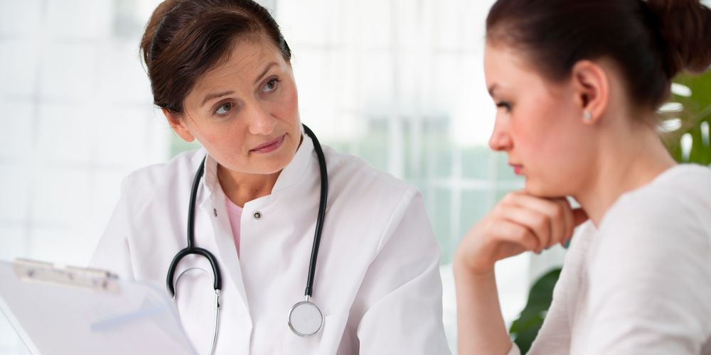 Eine Ärztin berät einen Patienten zur Behandlung von Leberkrebs. 