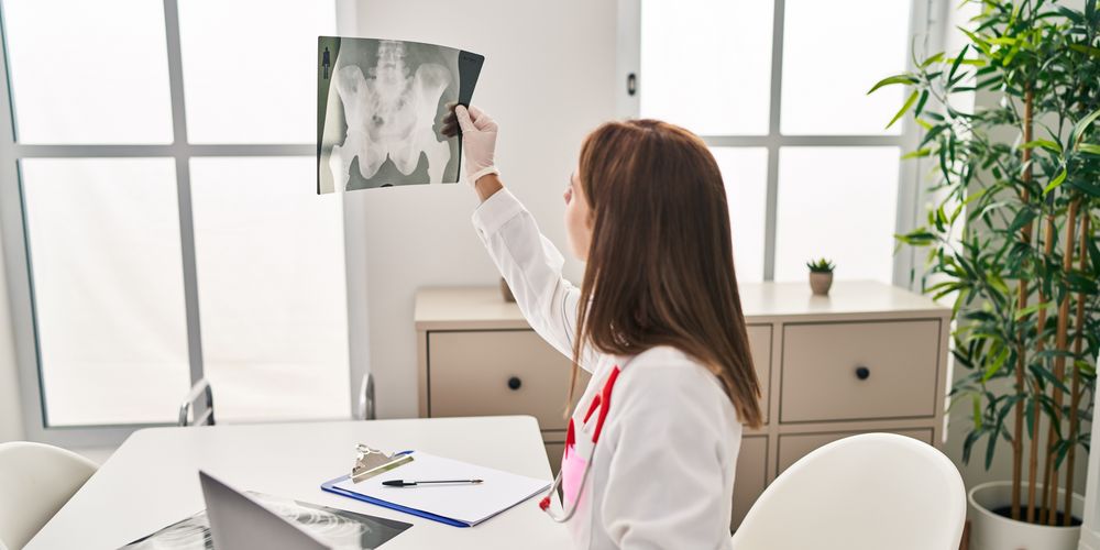 Eine Ärztin betrachtet ein Röntgenbild, das die Diagnose Osteonekrose sichert.