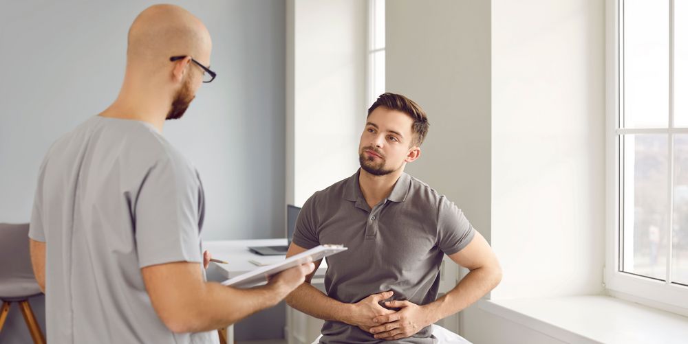 Ein Patient schildert einem Arzt seine Symptome, die für einen Zwerchfellbruch sprechen.