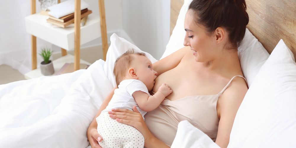 Eine Frau befindet sich in der Stillzeit mit einer Blasenentzündung im Bett.