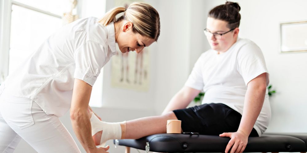 Ein Patient lässt seinen Hallux Valgus von einer Ärztin untersuchen.