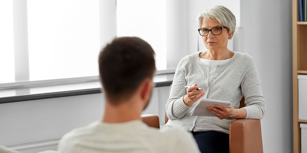 Eine Therapeutin spricht während einer Sitzung mit einem Patienten über seine Panikattacken.