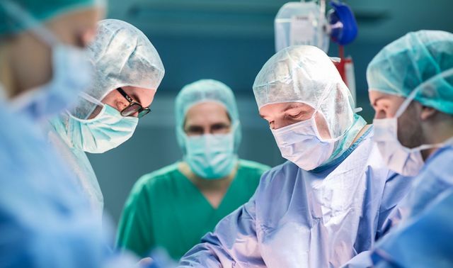 Ein Arzt sowie das medizinische Team der Orthopädie nehmen eine Operation an einem Patienten vor.