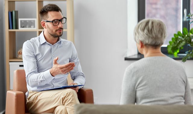 Ein Arzt berät eine betroffene Frau und informiert sie darüber, was eine Depression ist.