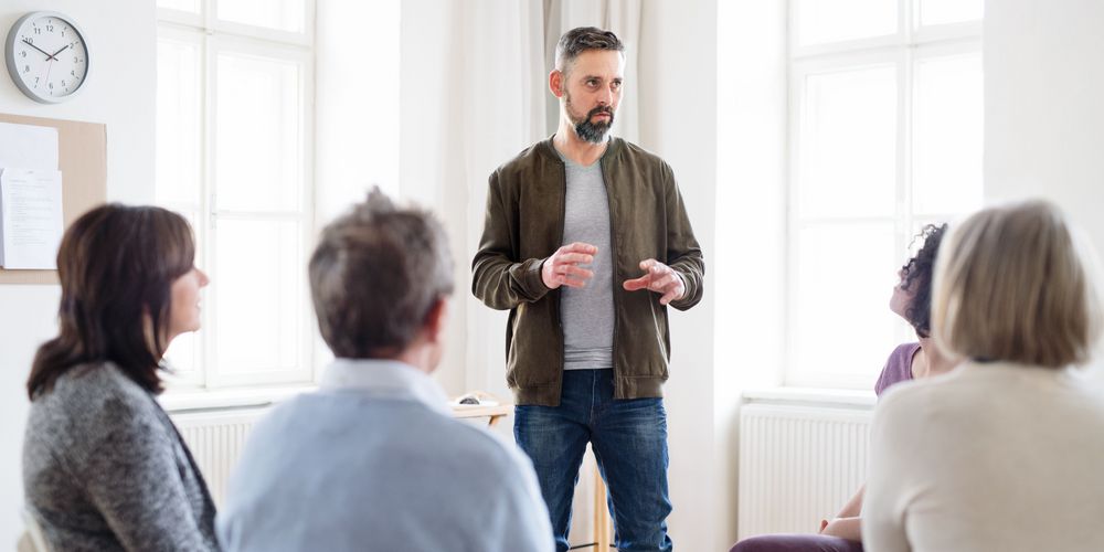 Ein Mann spricht in einer Gruppentherapie über den Alltag mit seiner Schizophrenie.