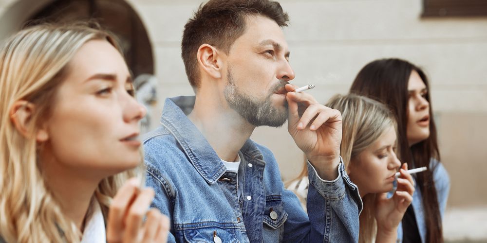 Eine Gruppe Mensch beim Rauchen, was ein Risikofaktor für Lungenkrebs ist.