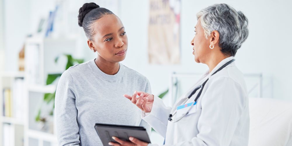 Eine Ärztin erklärt einer Patientin die Therapie für das Restless-Legs-Syndrom.