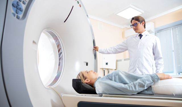Ein Arzt untersucht eine Patientin mittels CT-Scan vor der Mikrowellenablation ihres Tumors.