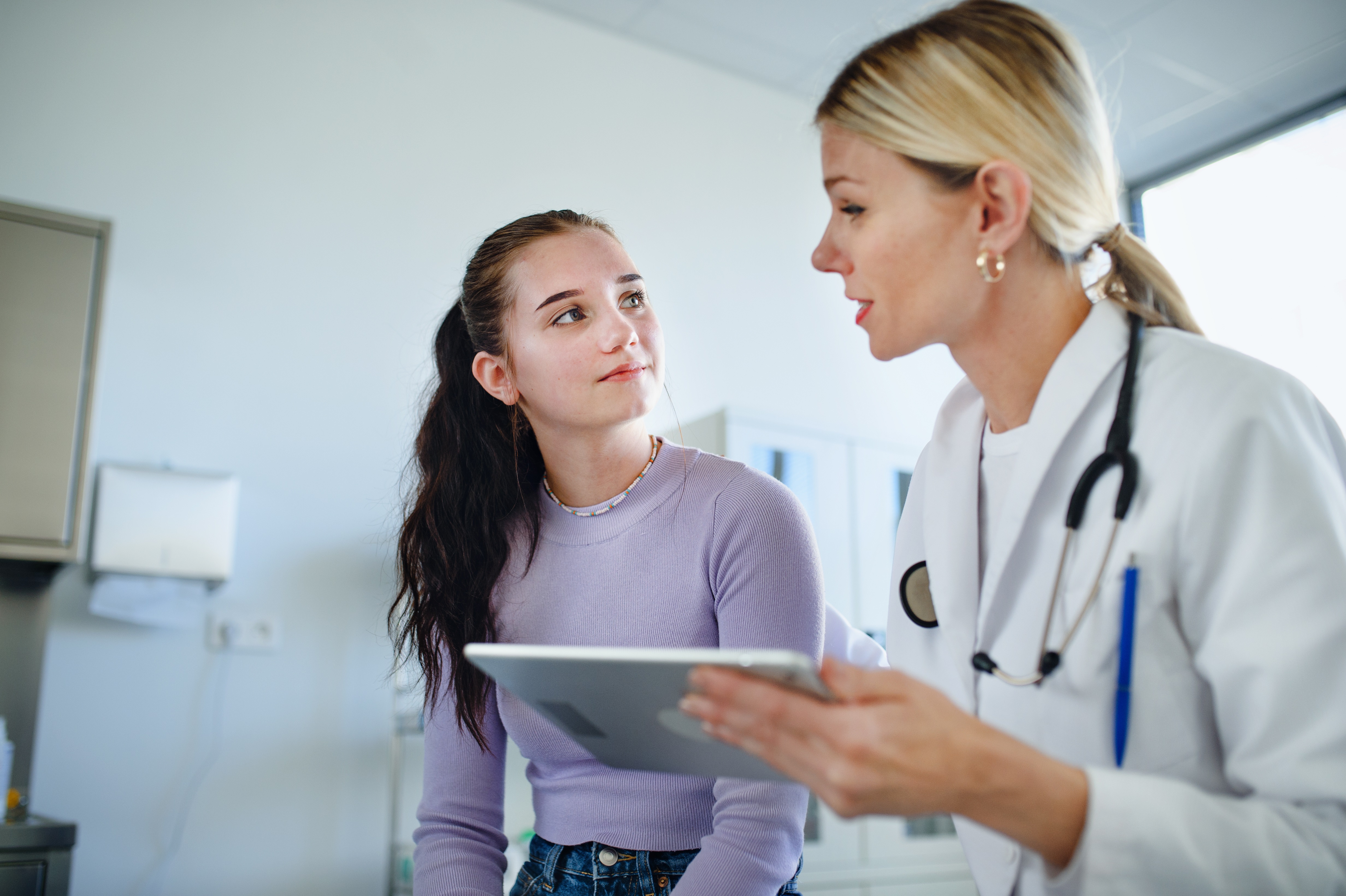 Eine Ärztin klärt ihre junge Patientin über den Blinddarm und mögliche Beschwerden auf.